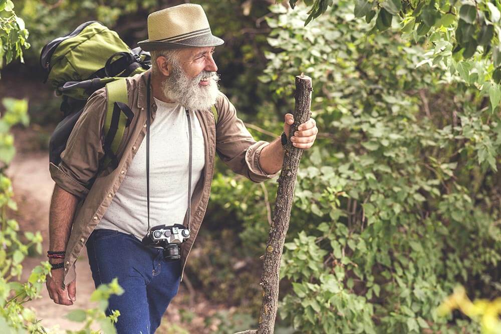 Older man hiking tin the woods