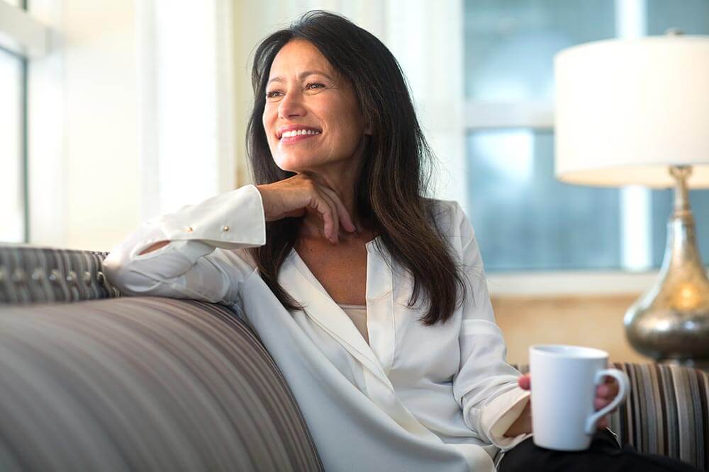 Woman enjoying coffee at home on a couch