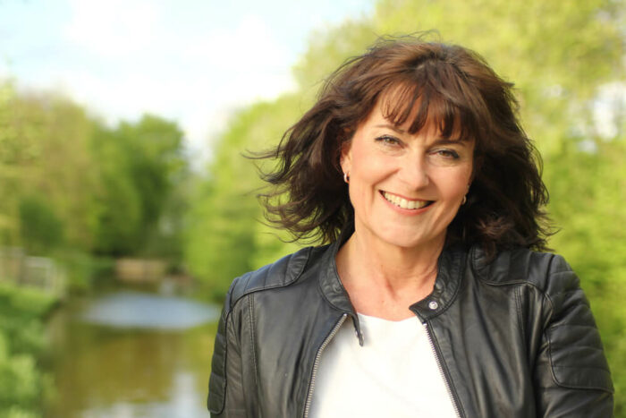 Middle-aged woman on bridge over river