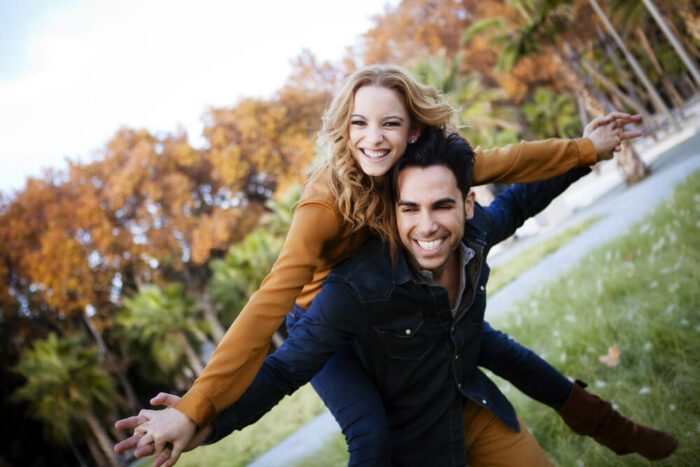 young couple with arms spread wide