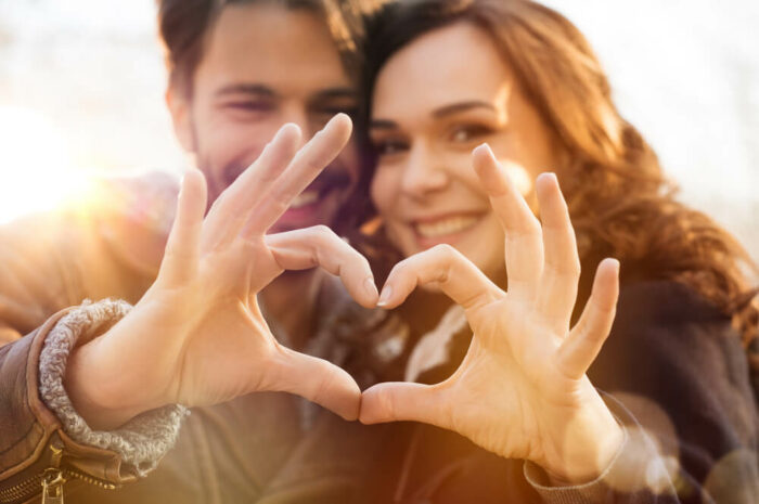 young couple making a heart with hands